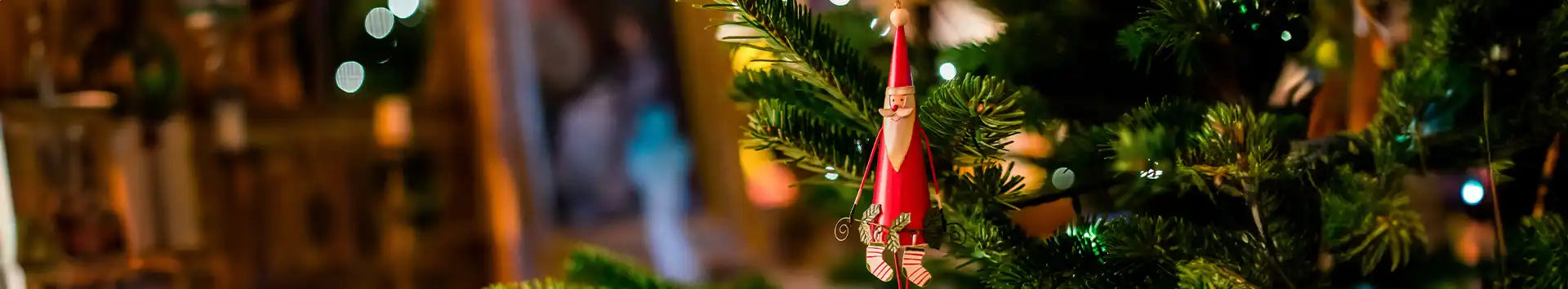 A Santa decoration hanging on a Christmas Tree, representing the Hanging Christmas Decorations collection at Premier Christmas